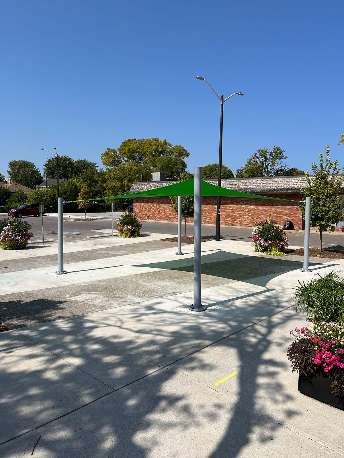 A versatile, surface-mounted shade structure in a city square, demonstrating how Sun Shade Co.'s flexible installations can reduce heat in high-traffic urban spaces.
